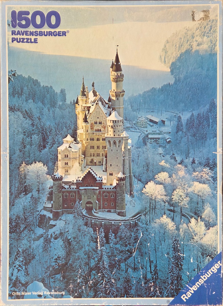 Neuschwanstein Castle in winter, covered in snow, surrounded by a frozen forest.