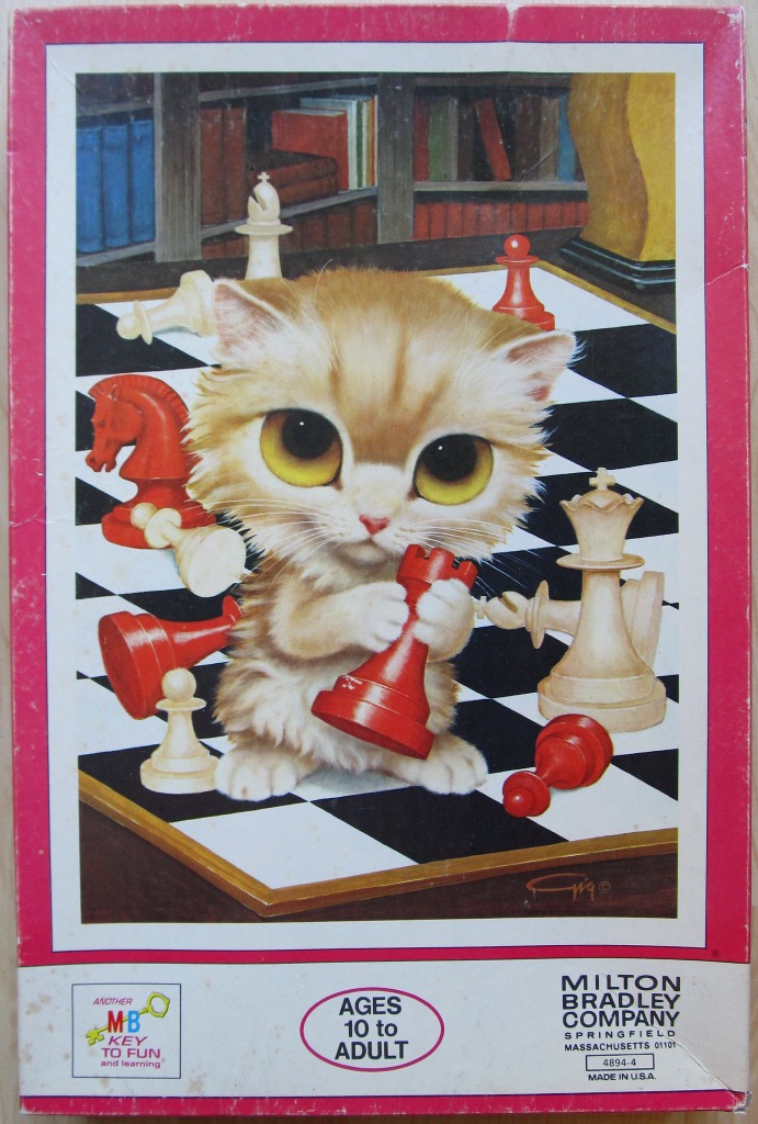 A fluffy ginger kitten holding a red chess rook piece on a checkered chessboard.