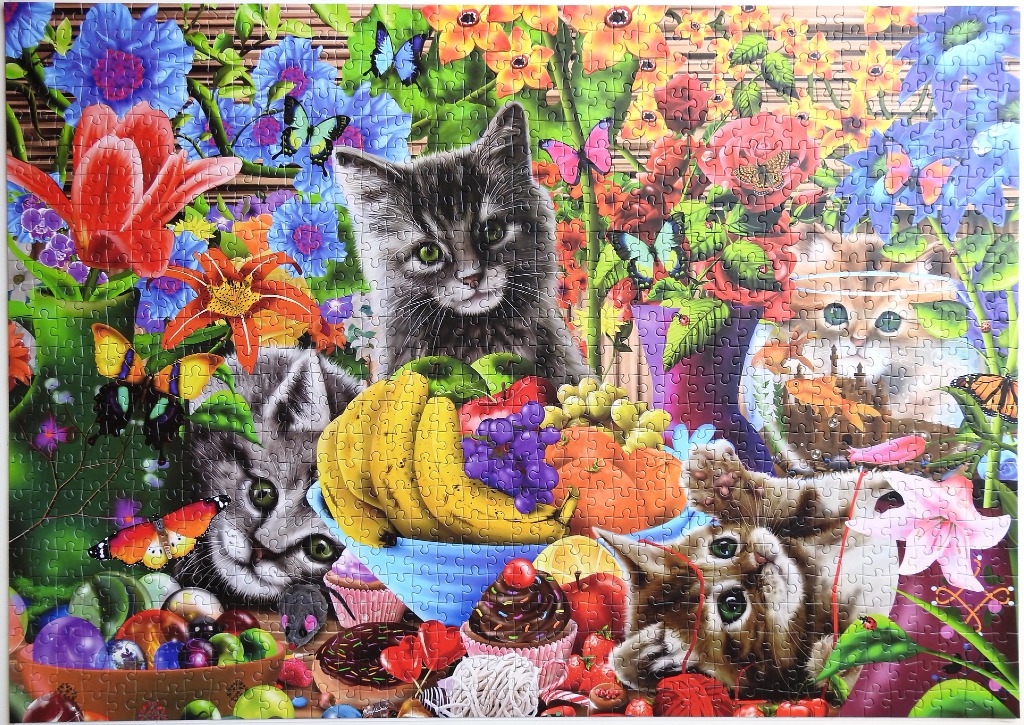 Three kittens playing among vibrant flowers, butterflies, and a bowl of fruit.
