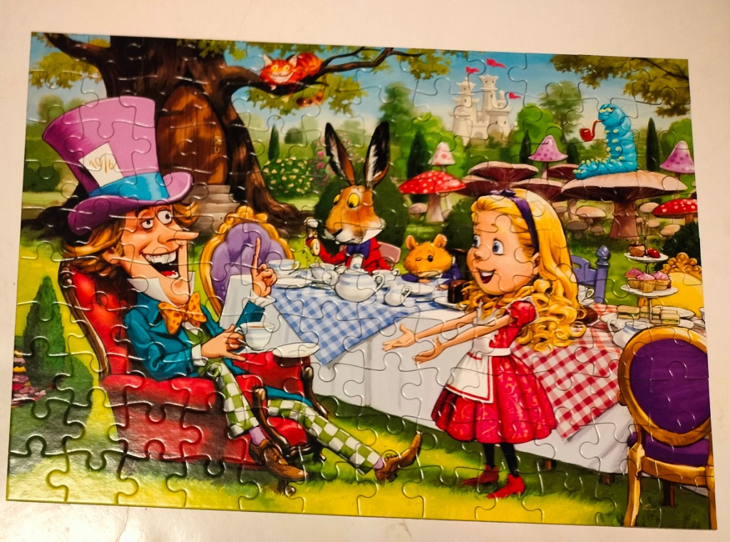 A whimsical illustration of a Mad Hatter tea party with Alice, the March Hare, and other characters in a garden setting.