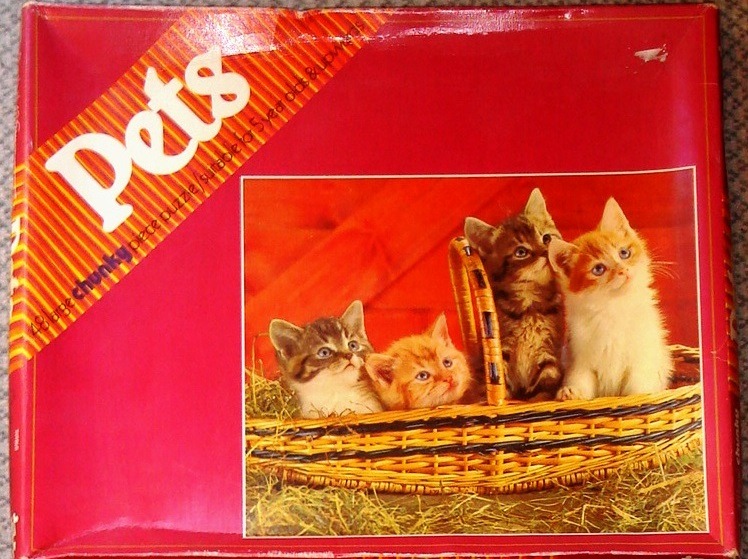 Four kittens sitting in a wicker basket against a red background.