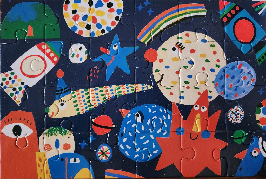 Whimsical, colourful cartoon space scene featuring planets, rockets, and smiling creatures against a dark blue background.