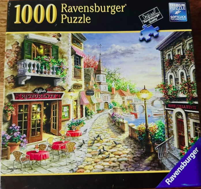 An illustration of a cobblestone Italian village street featuring an outdoor cafe by a canal.