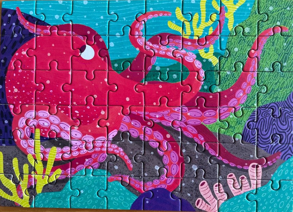 A whimsical illustration of a bright pink octopus swimming among colorful underwater coral and sea plants.