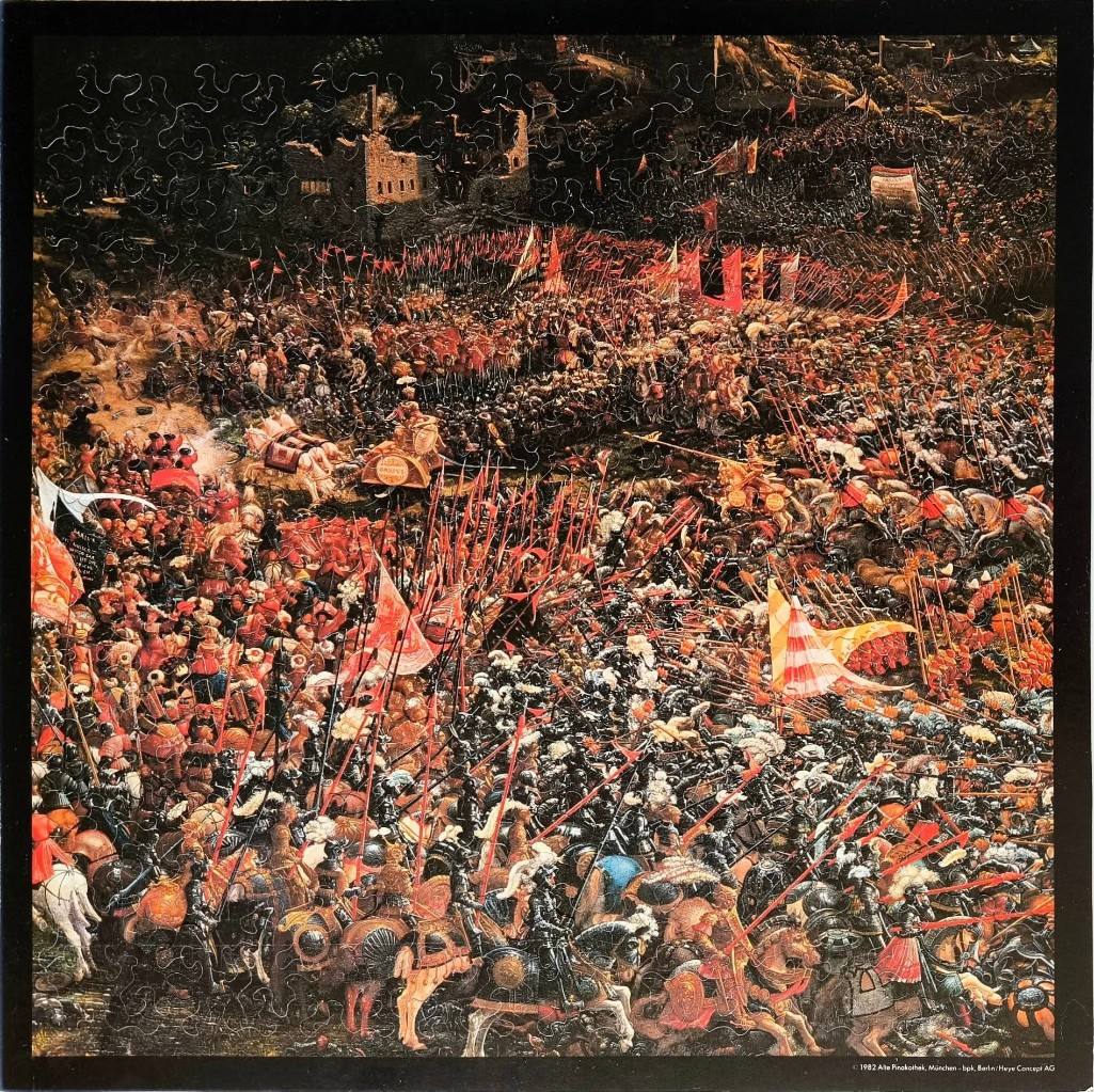 A dense, chaotic historical painting of a medieval battle scene featuring knights, horses, and numerous red banners.