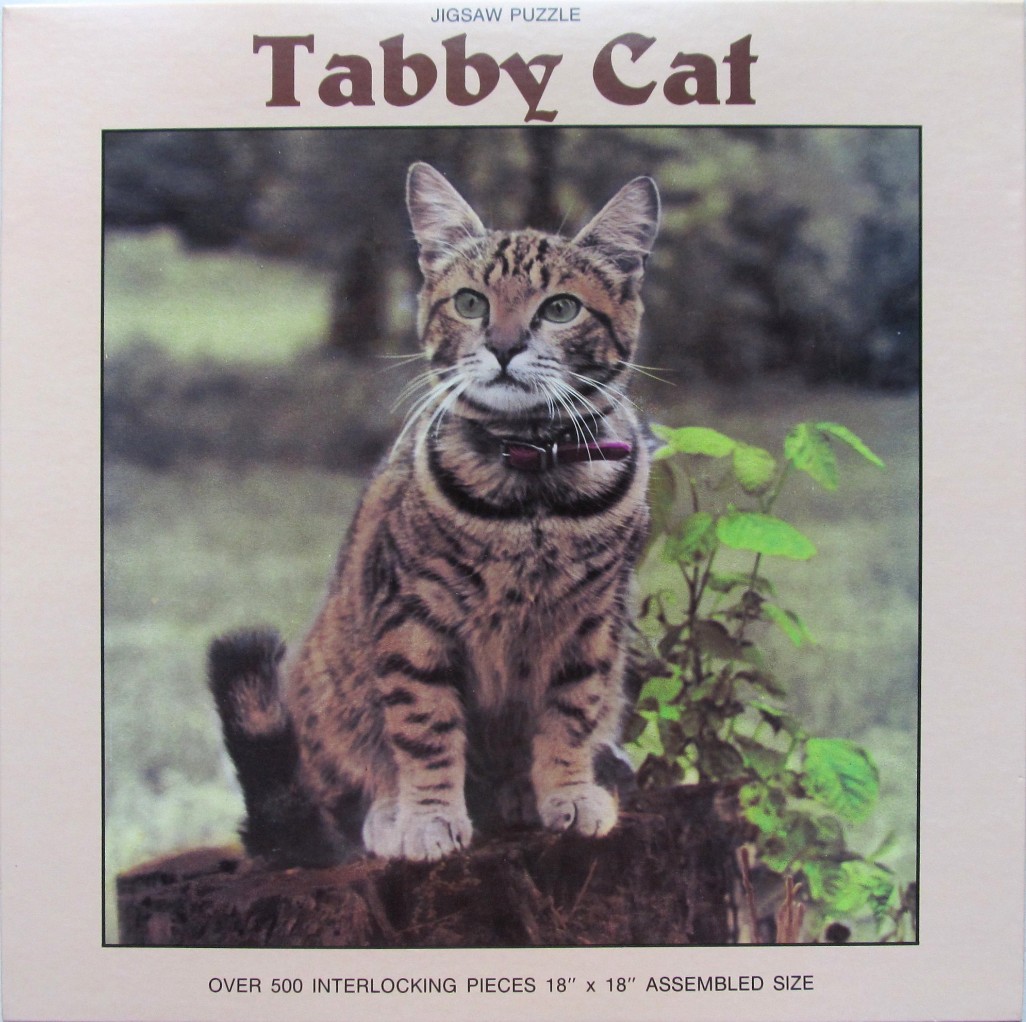 A photographic portrait of a brown tabby cat sitting on a tree stump in an outdoor setting.