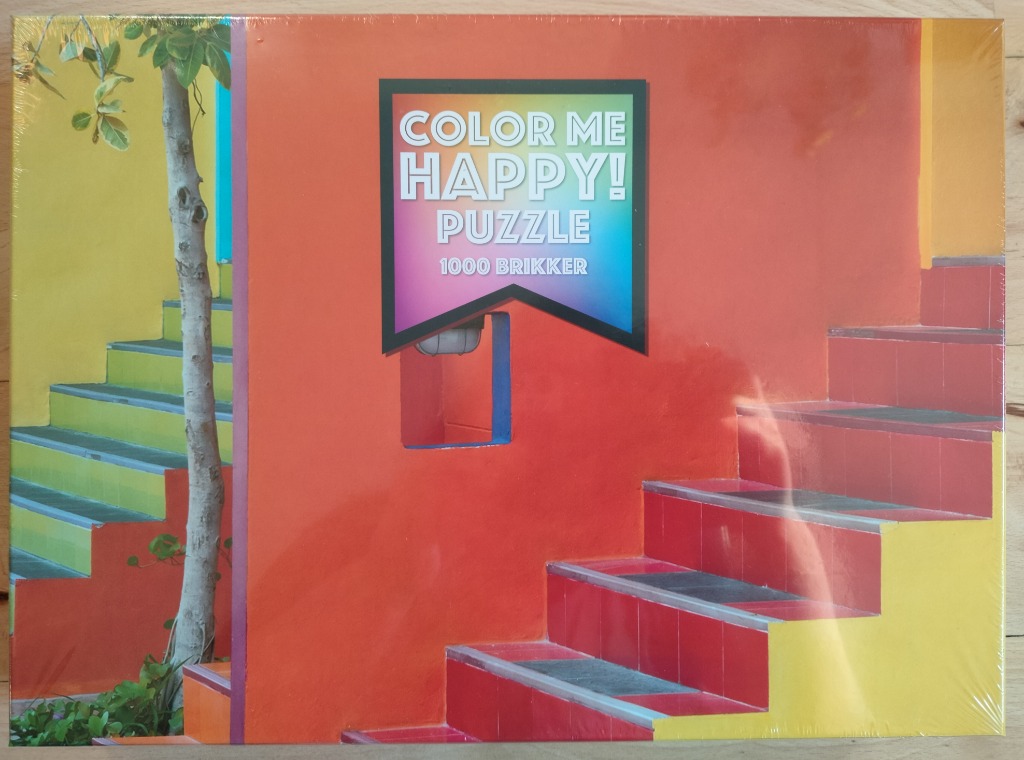 A vibrant architectural scene featuring bold orange, yellow, and red staircases with a tree in the foreground.