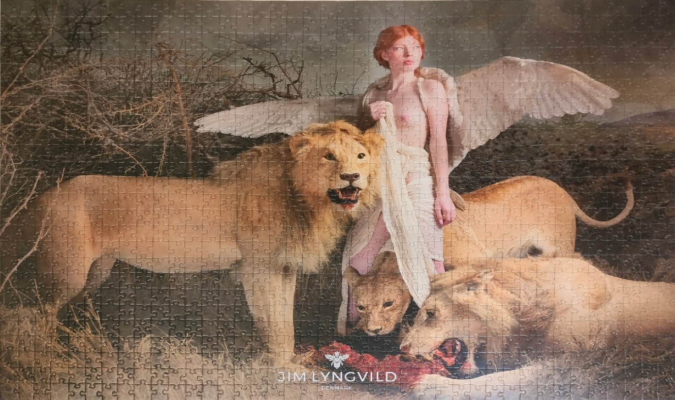 A pale, red-haired winged figure standing amidst three lions in a desolate landscape.