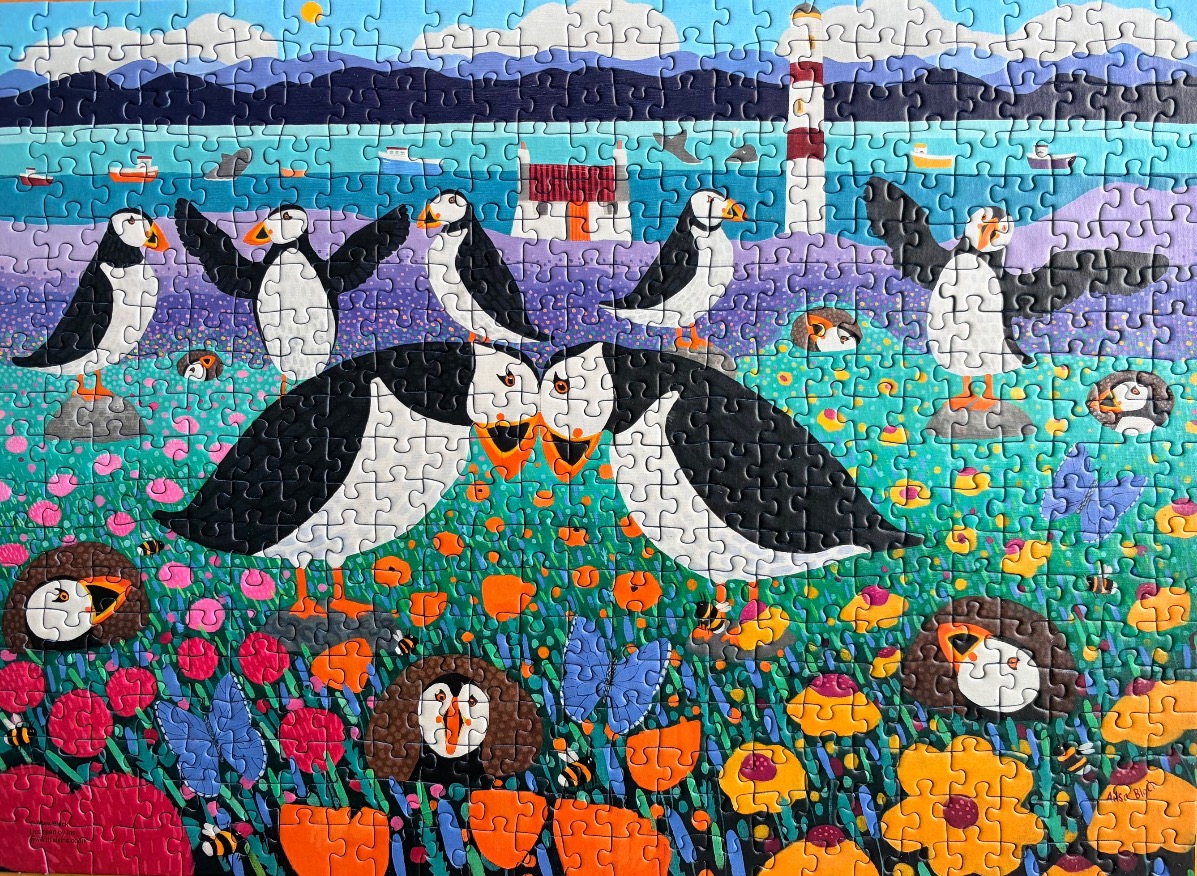 A whimsical folk-art style illustration of puffins in a vibrant wildflower meadow by the sea.