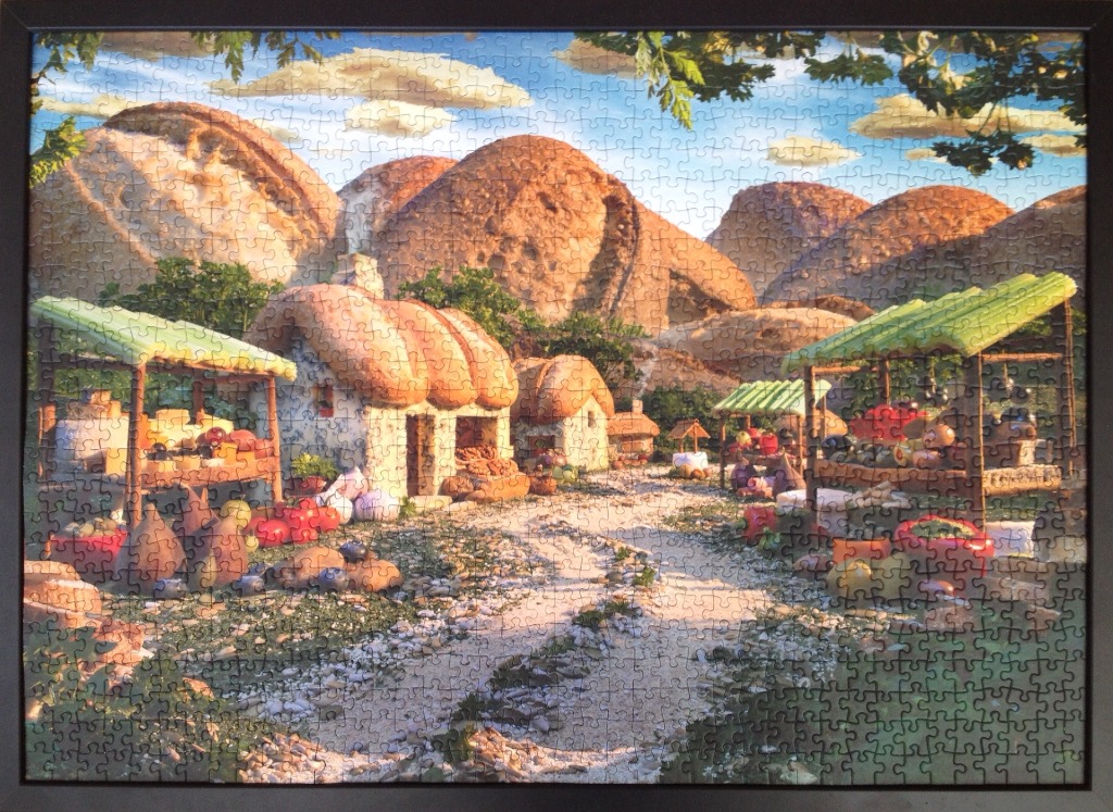 A whimsical fantasy illustration of an outdoor market nestled in front of giant, bread-like boulder mountains.
