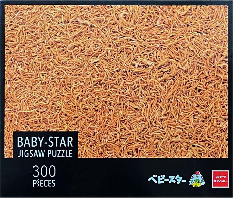 A top-down photographic view of a dense pile of golden-brown dried noodle snacks.