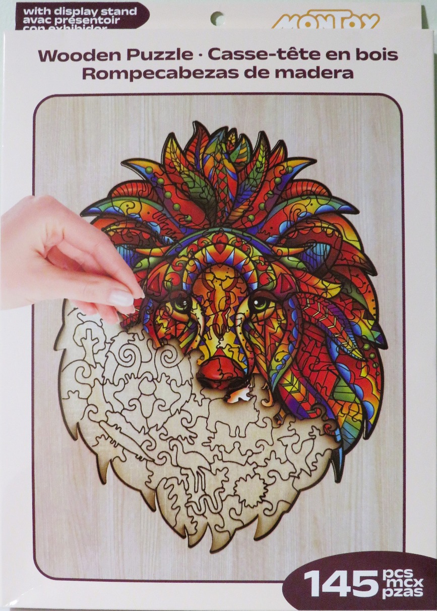 A hand places a piece into a colorful, abstract illustration of a lion's head on a wooden background.