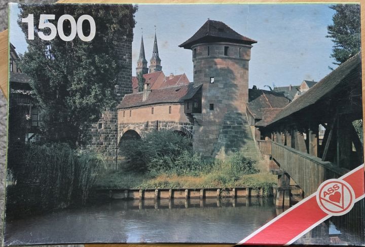 A photograph of a medieval stone tower and bridge over a canal in Nuremberg, Germany.