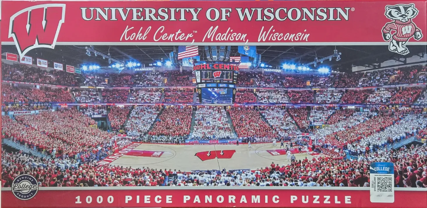 A panoramic view of the crowded Kohl Center basketball arena filled with fans wearing red and white.