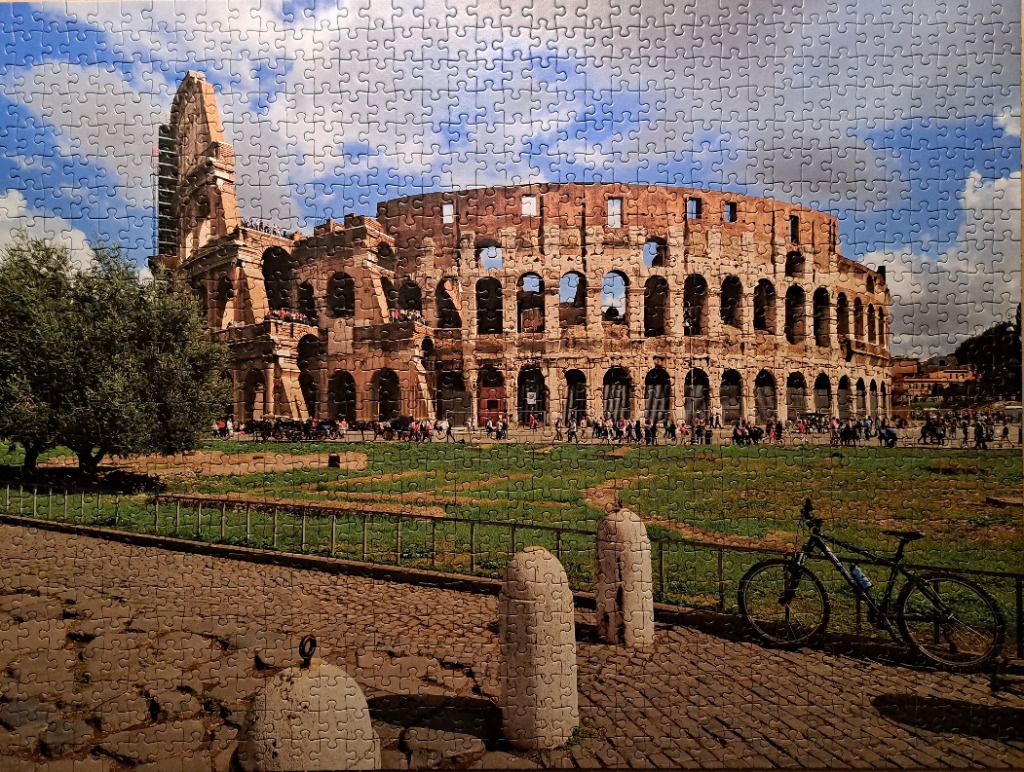 The Colosseum in Rome viewed from a stone plaza with a bicycle in the foreground.