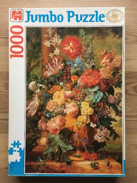 A lush, oil-painting style floral still life featuring a variety of colorful flowers in an ornate stone urn.