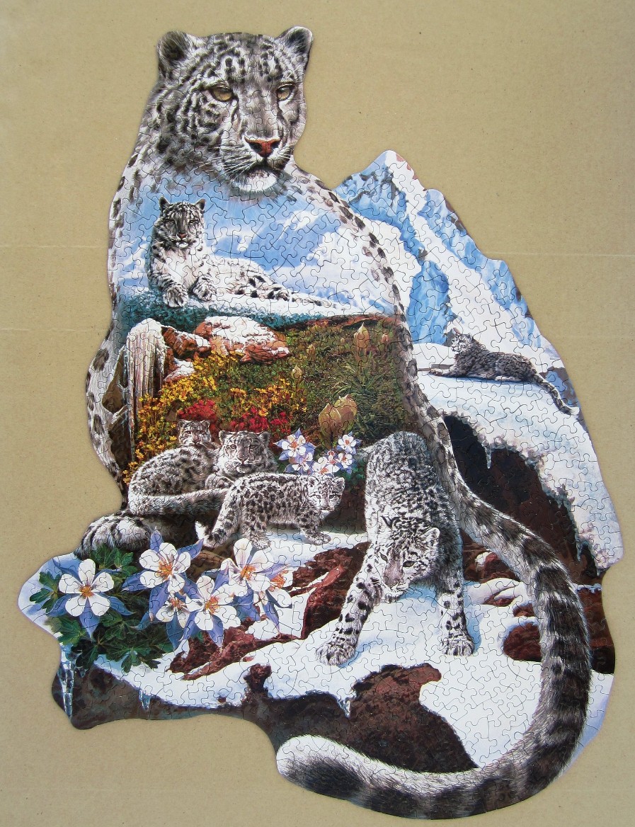 A double-exposure illustration of a large snow leopard containing scenes of a family of snow leopards in mountain terrain.