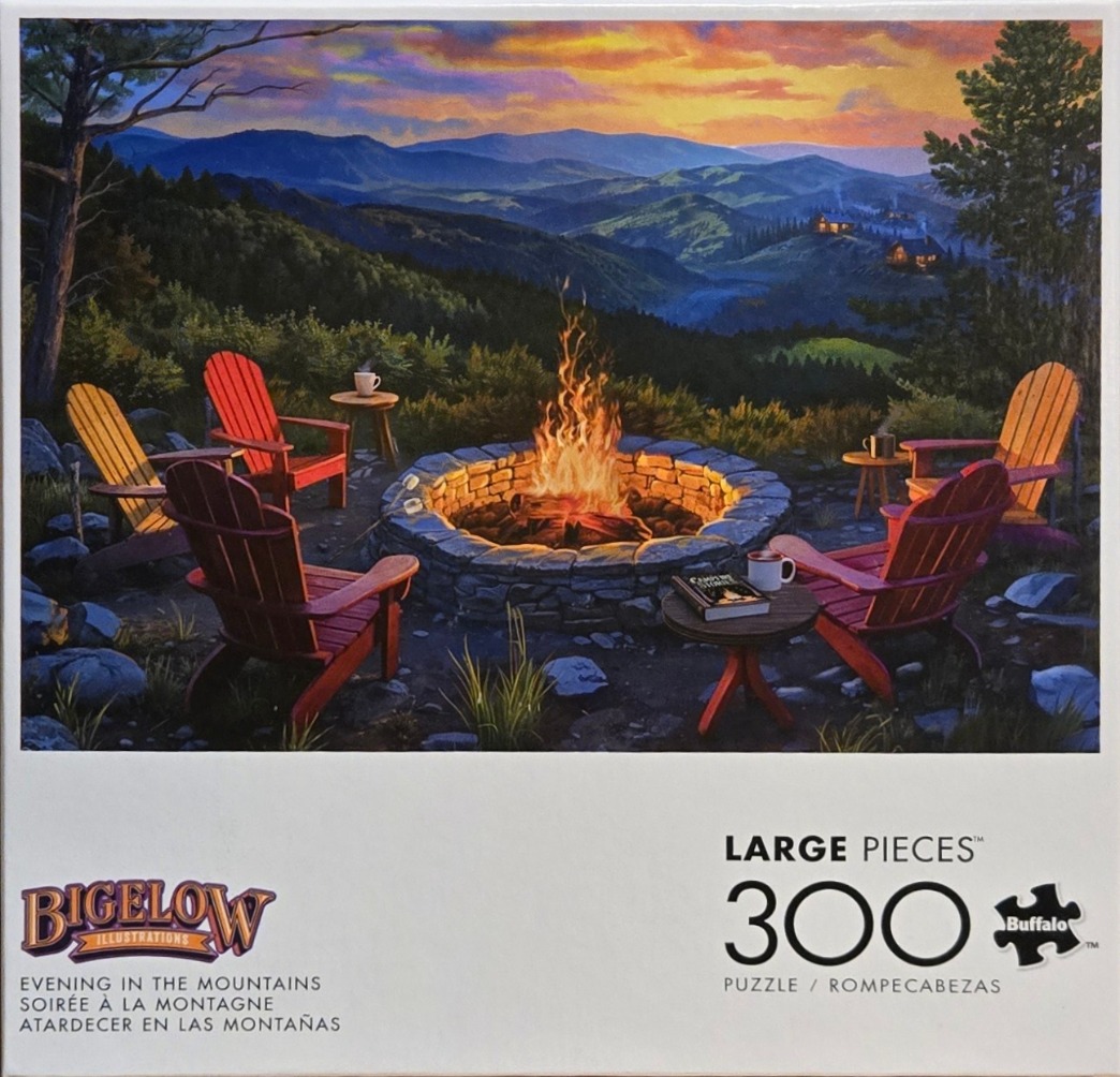 A campfire glowing at twilight in front of a mountain landscape with four Adirondack chairs.