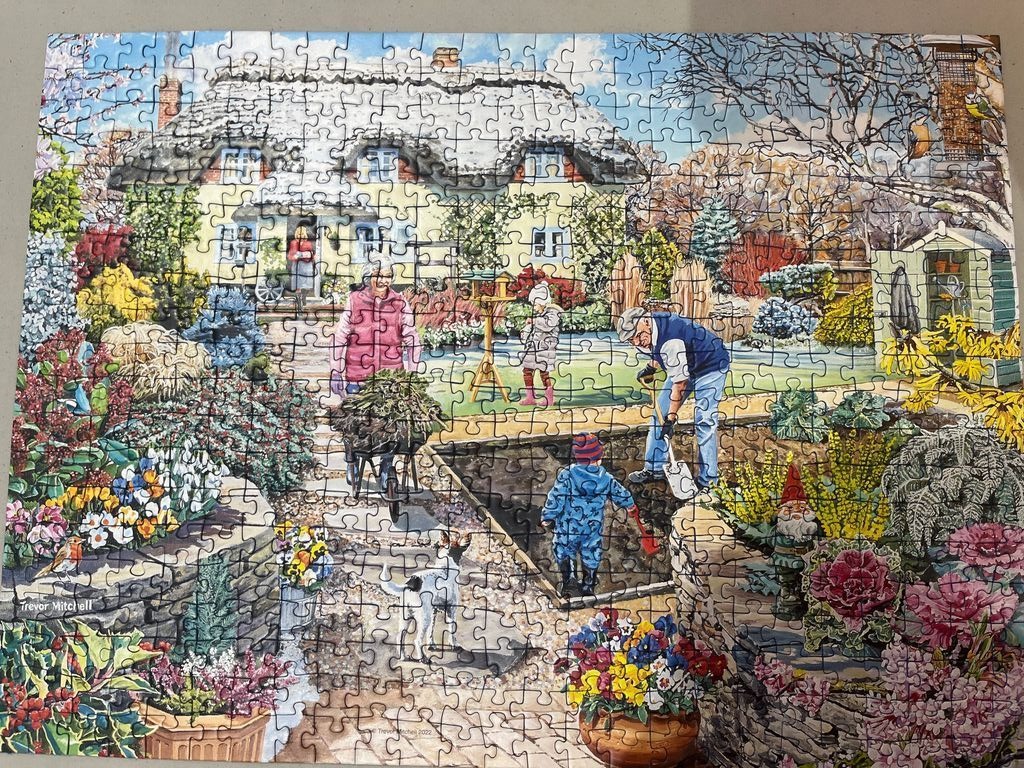 A detailed illustration of a multi-generational family gardening in front of a thatched-roof cottage in spring.