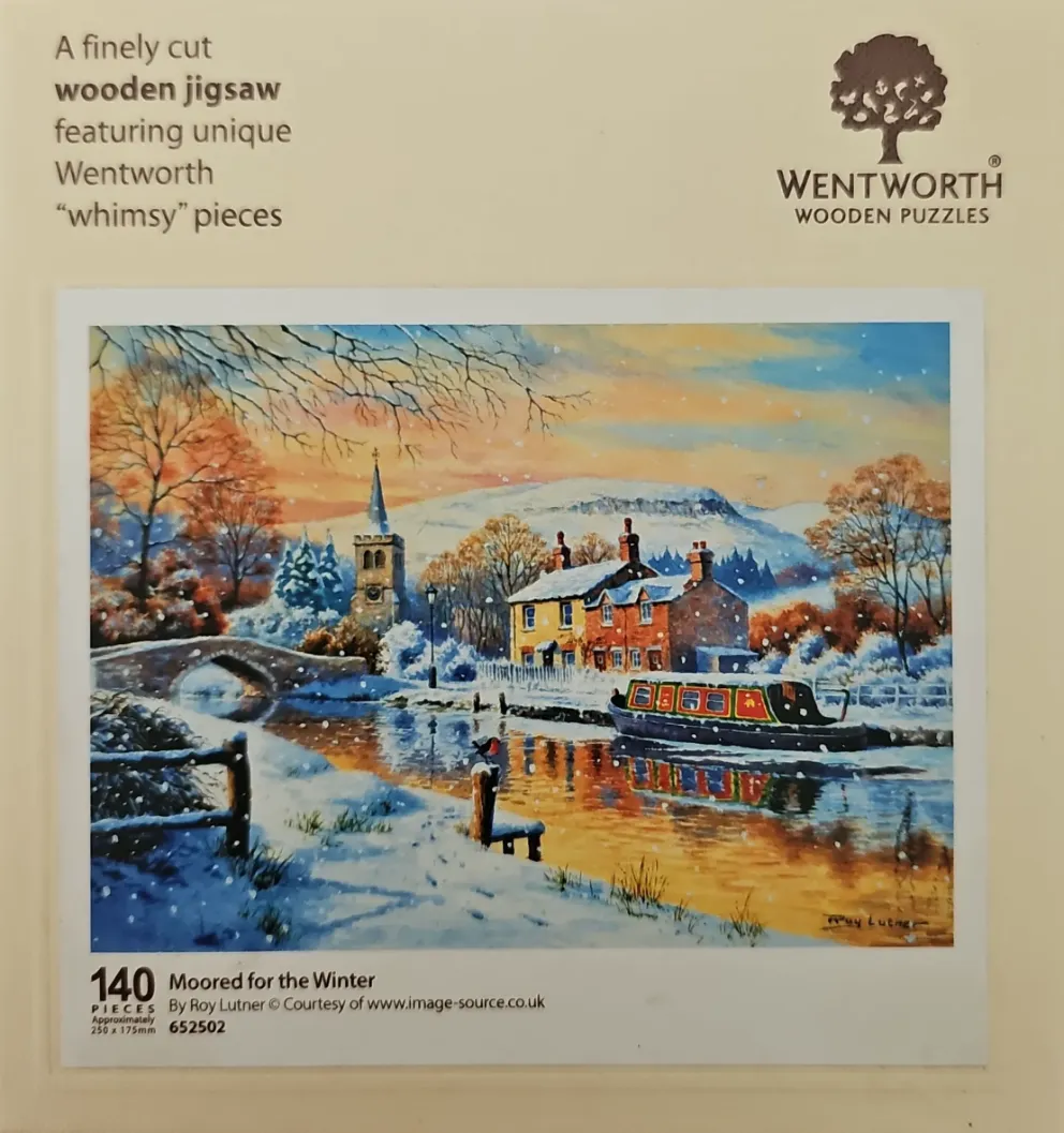 A festive winter canal scene featuring a narrowboat, a stone cottage, and a church tower at sunset.