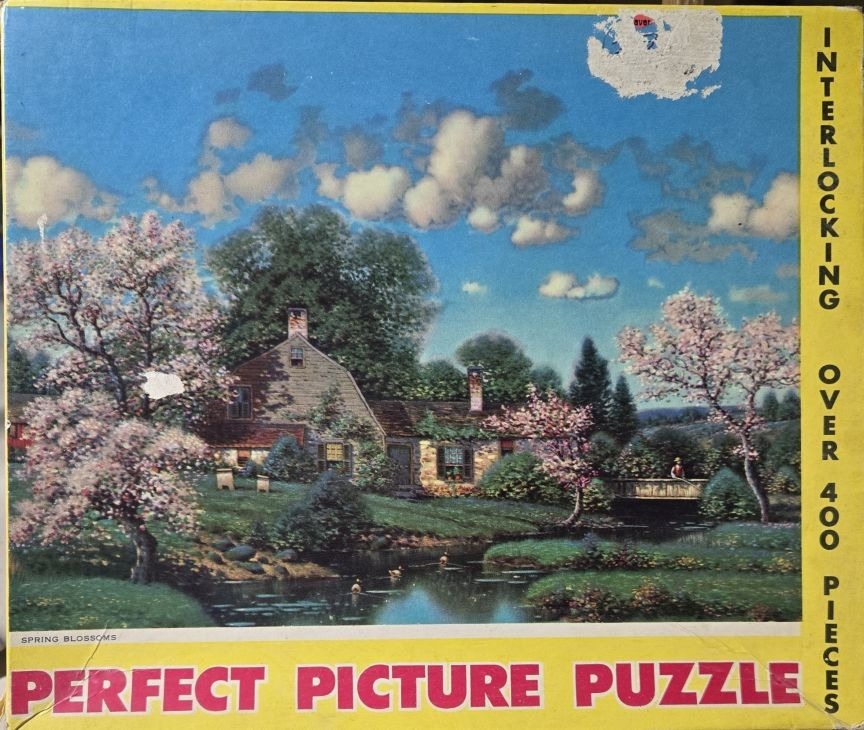 An idyllic countryside scene with a stone farmhouse, a small stream, and blossoming trees in spring.