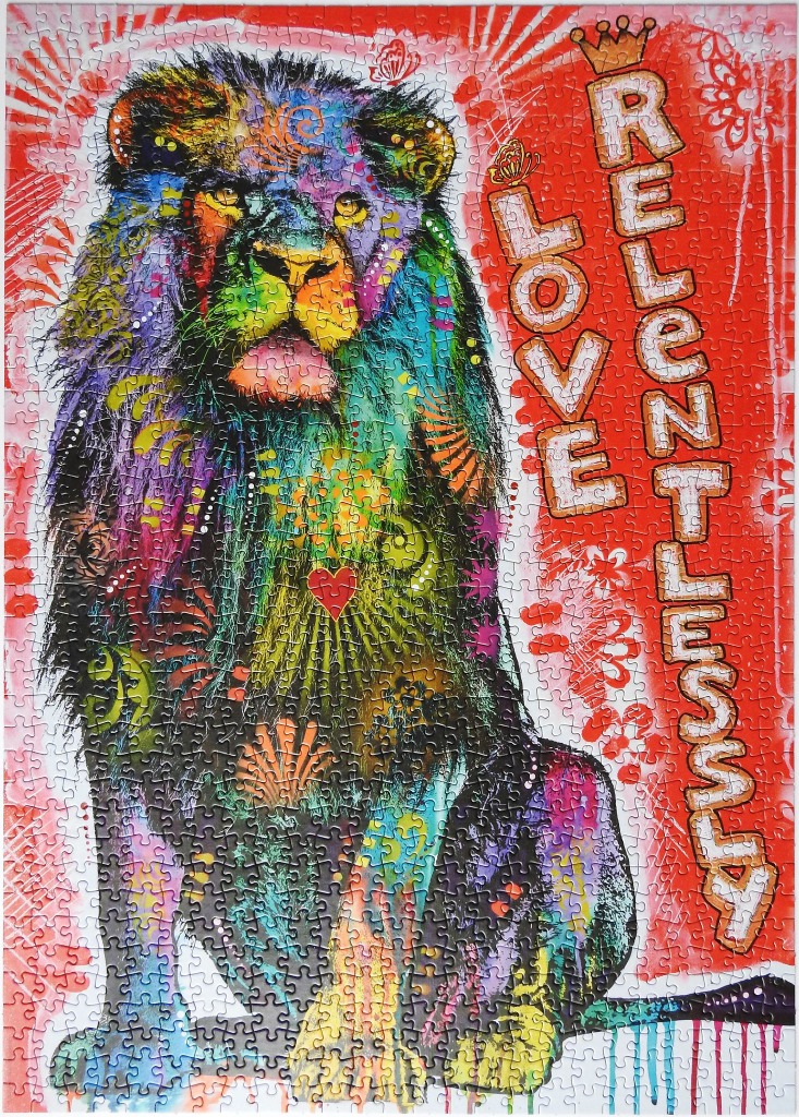 Colorful artistic portrait of a lion sitting against a bright red background with the text LOVE RELENTLESSLY.