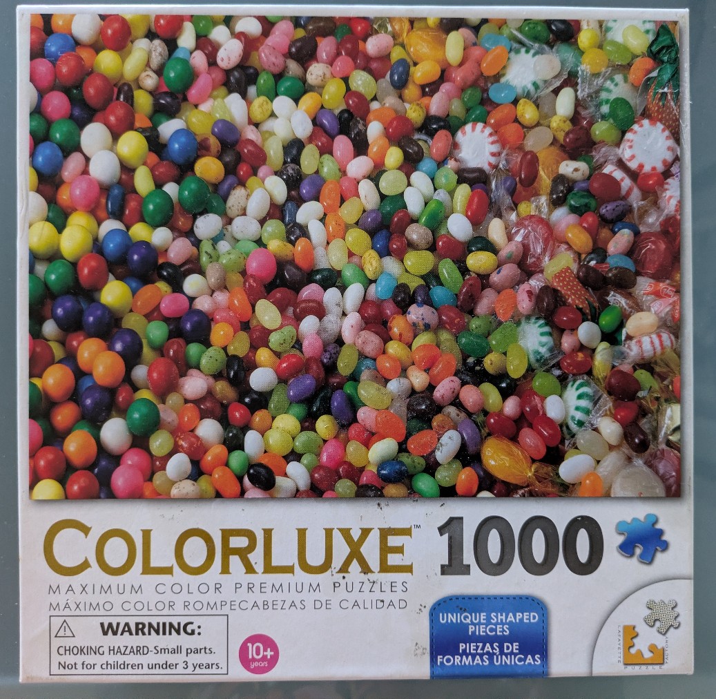 A close-up photograph of a overflowing mix of colorful jelly beans and wrapped candies.