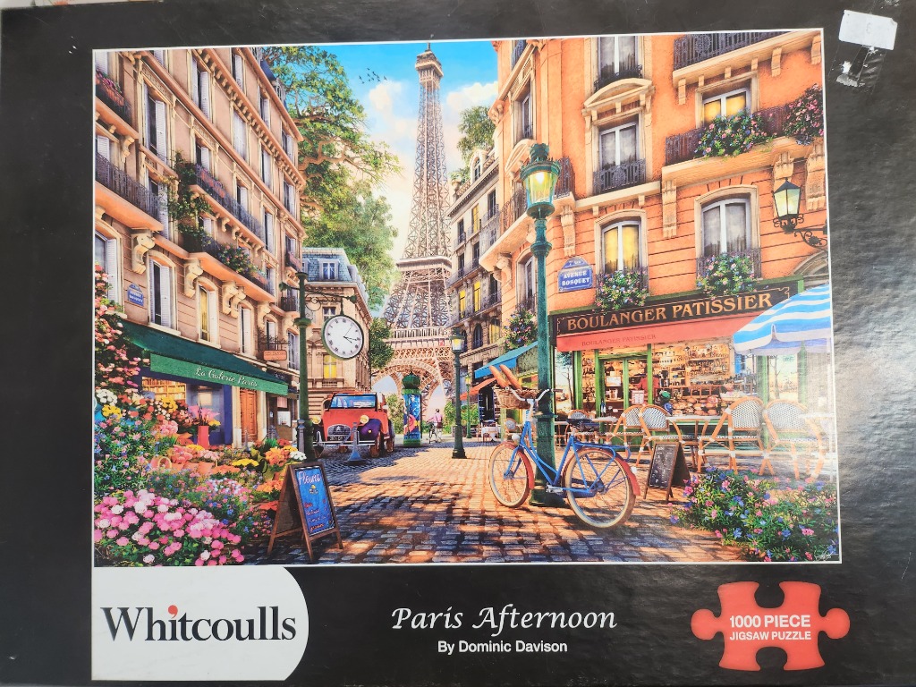 A sunny Parisian street scene featuring the Eiffel Tower in the background, a bakery, and a blue bicycle.