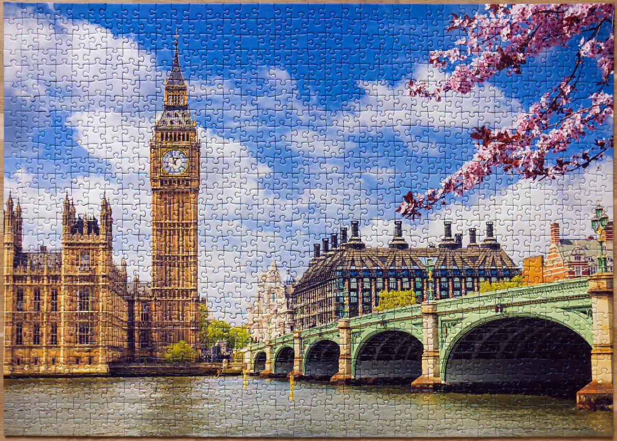 A sunny day view of the Elizabeth Tower in London with cherry blossoms in the foreground.