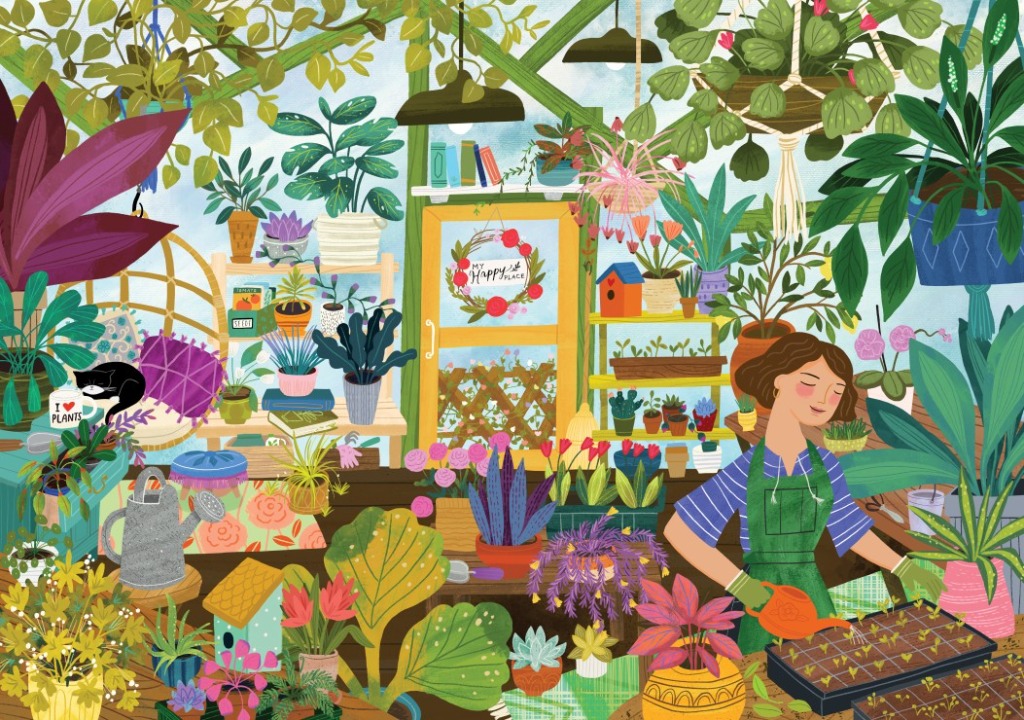 A woman in a green apron watering seedlings in a greenhouse filled with lush plants and flowers.