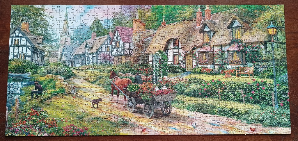 A peaceful English village scene with thatched cottages, a horse-drawn cart, and a small stream.