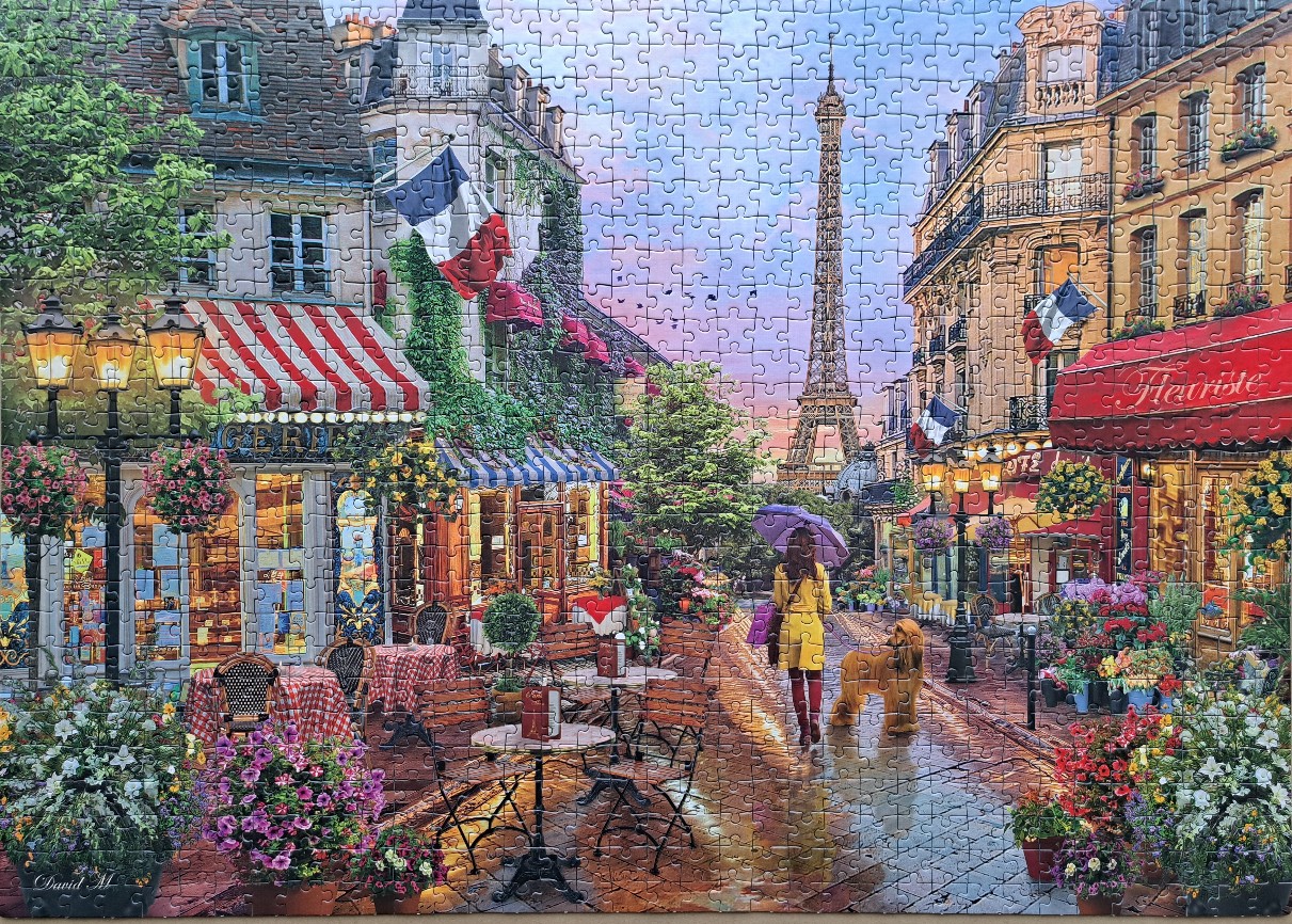 A Parisian street scene with the Eiffel Tower in the distance, featuring a flower shop, cafe tables, and a woman walking.