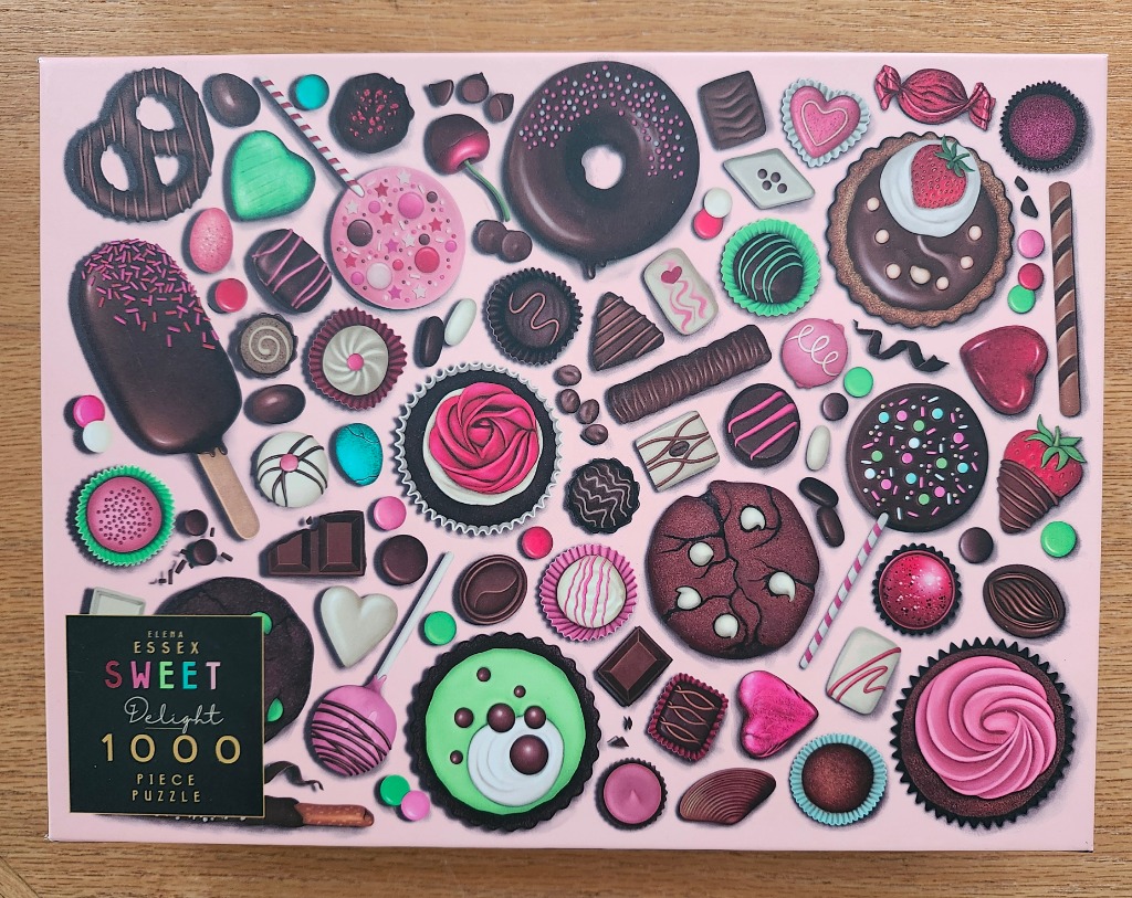 An assortment of chocolates, cookies, and candies scattered on a pale pink background.