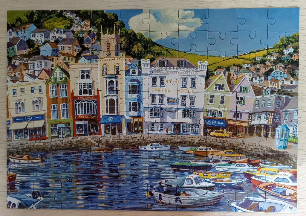 A vibrant painting of a harbor in Dartmouth, England, with colorful buildings and anchored boats.