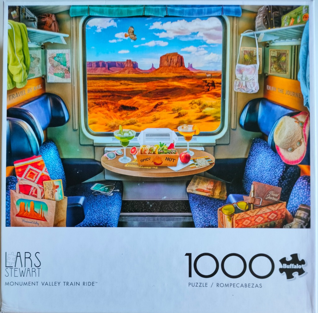 View from a train car window looking out onto a vibrant desert landscape with Monument Valley buttes.