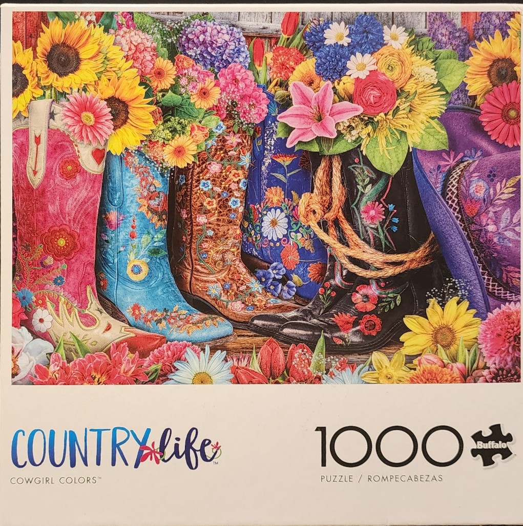 A row of colorful, embroidered cowboy boots overflowing with bright, diverse spring flowers.