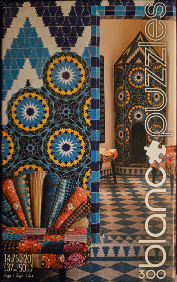 Interior view featuring intricate blue and yellow Moroccan-style tilework and a colorful upholstered patchwork chair.