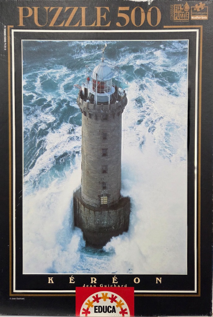 Aerial photograph of the Kéréon lighthouse surrounded by turbulent, crashing ocean waves.