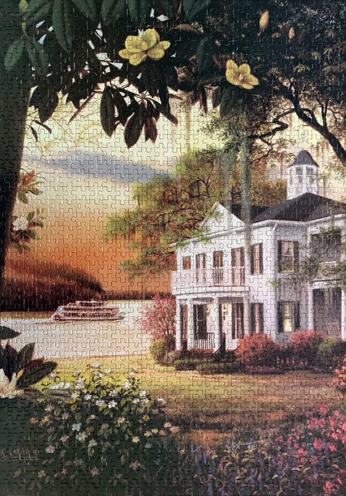 A southern plantation home by a river with a steamboat at sunset, framed by magnolia flowers and foliage.