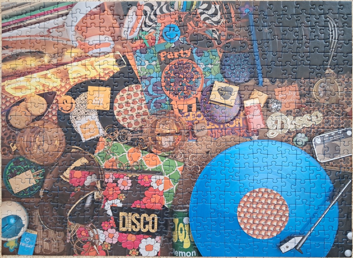 A flat-lay collage of 1970s-inspired disco and party items, including a blue vinyl record, snacks, and retro patterns.