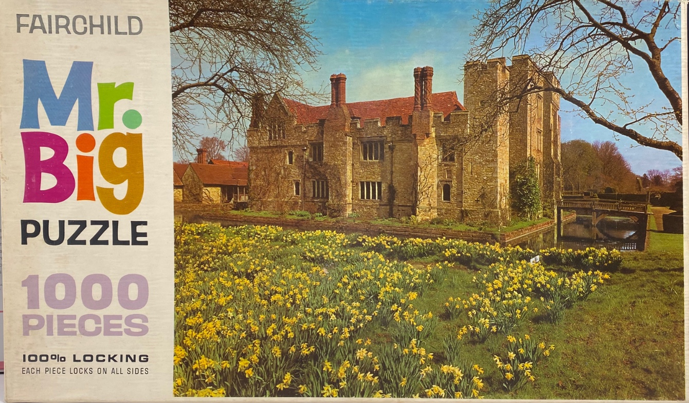 A stone manor house surrounded by a large field of yellow daffodils, viewed on a sunny day.