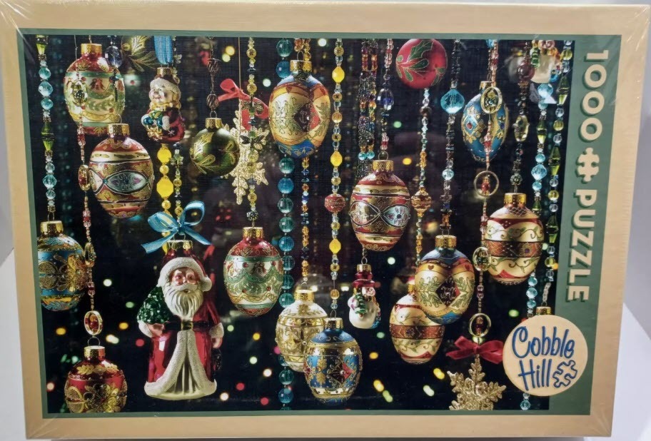 A collection of ornate, vintage-style Christmas ornaments hanging against a dark background with blurred fairy lights.