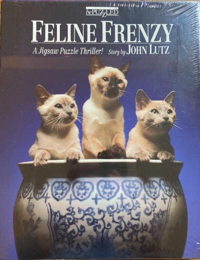 Three Siamese kittens sitting inside a large, blue-and-white patterned ceramic bowl against a blue background.