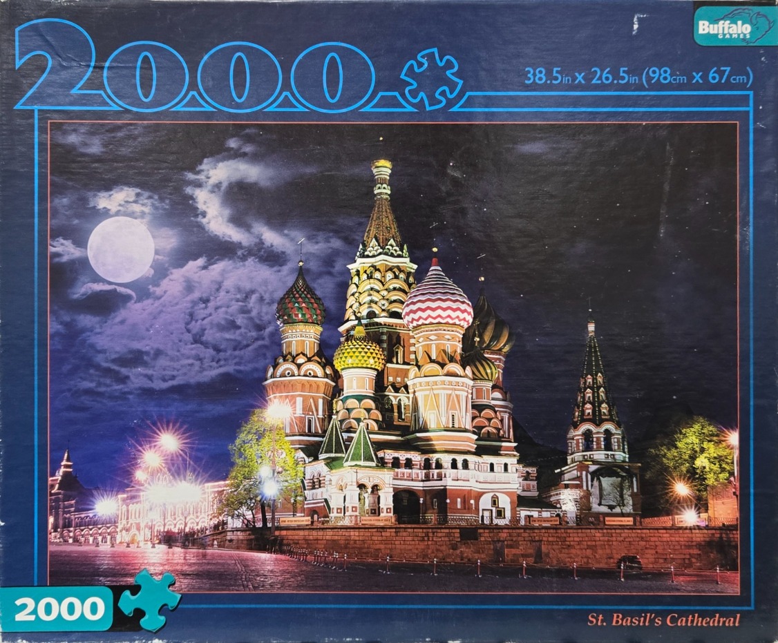 A nighttime view of the brightly lit St. Basil’s Cathedral in Moscow under a full moon.
