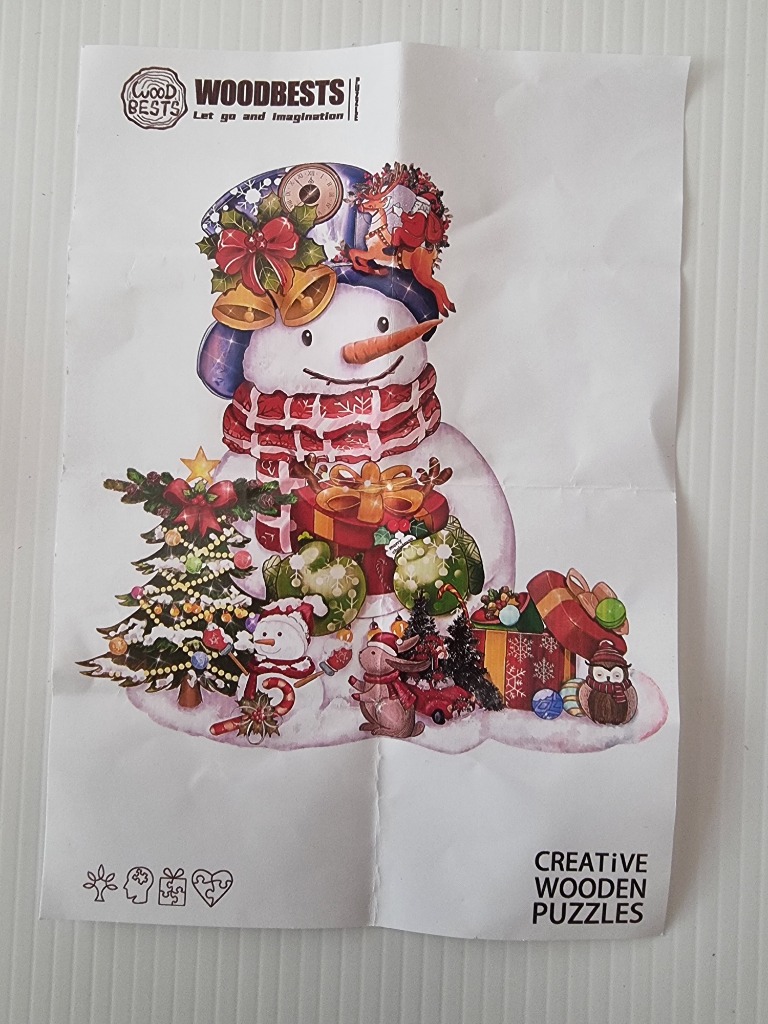A whimsical illustration of a snowman surrounded by Christmas presents, a decorated tree, and woodland creatures.