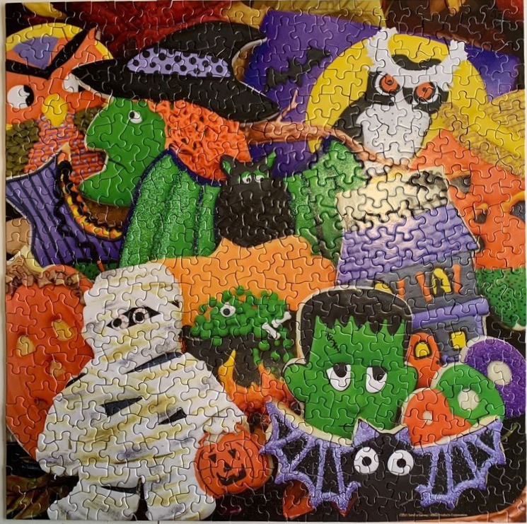 A whimsical collage of cartoonish Halloween characters including a mummy, Frankenstein, a witch, and a haunted house.