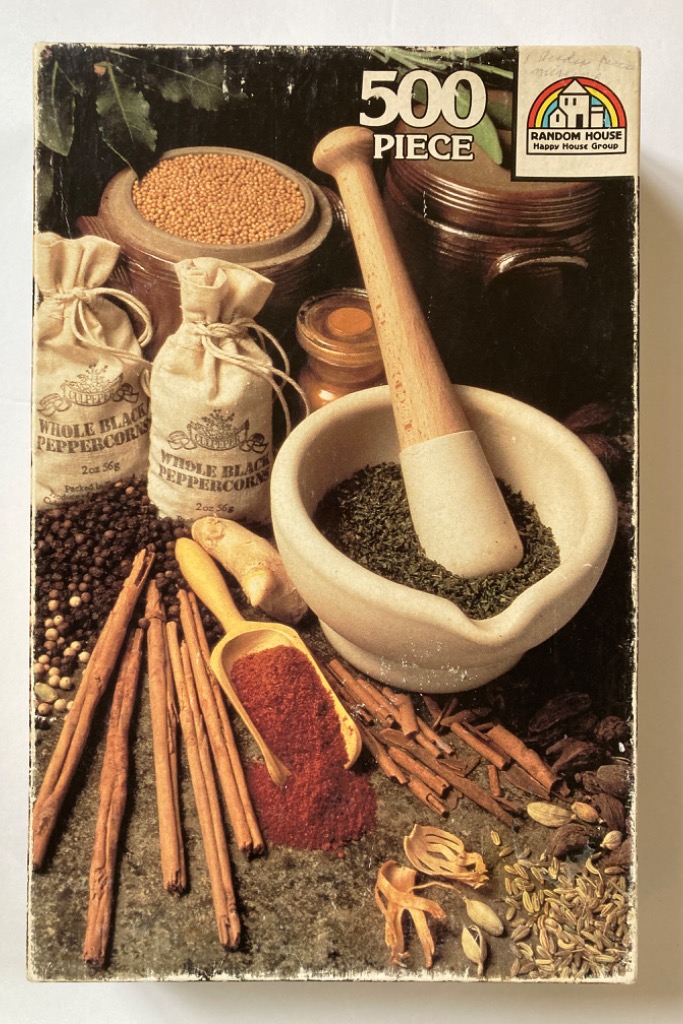 A still life photograph featuring various herbs, spices, peppercorns, and a mortar and pestle.