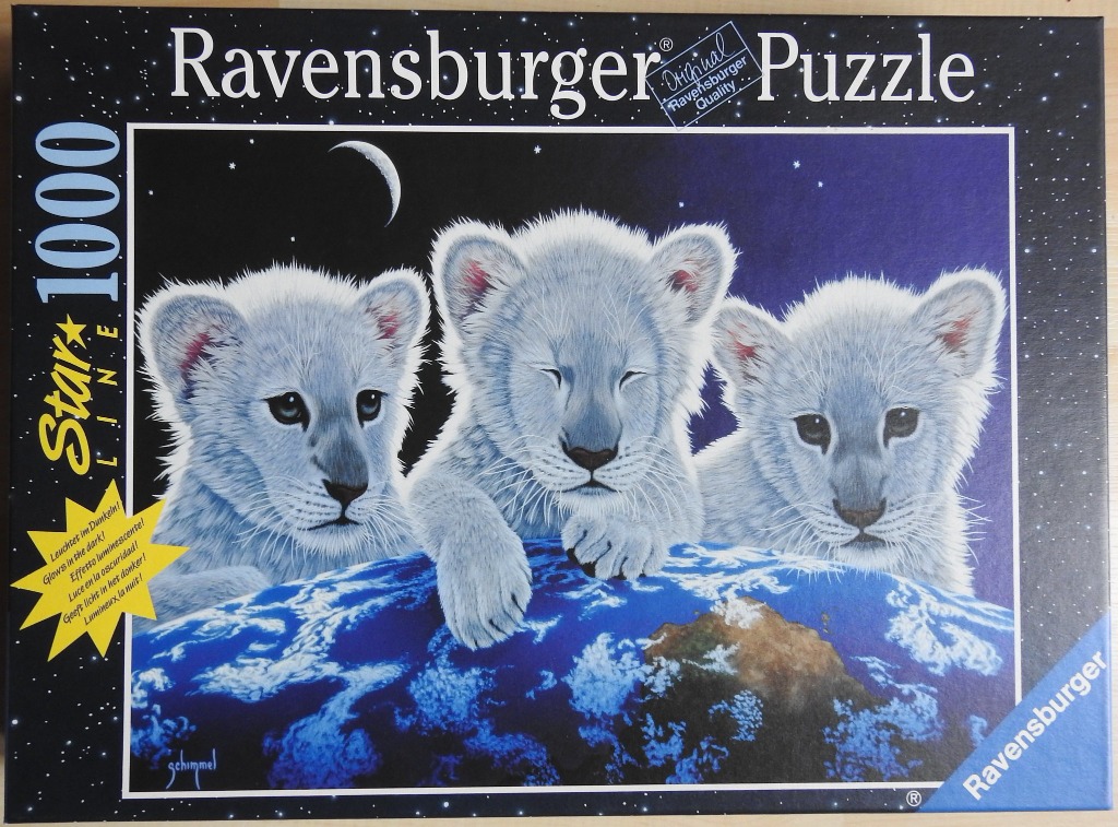 Three fluffy white lion cubs perched on top of a globe against a starry night sky.