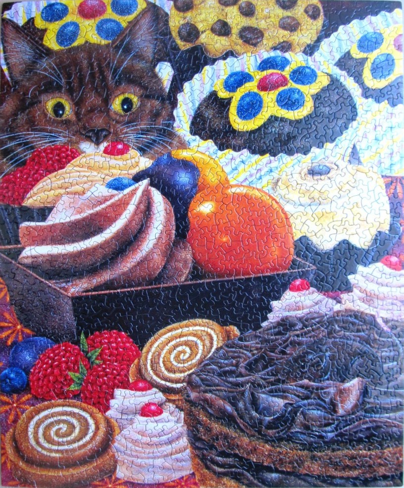 A curious dark brown cat peering over a collection of colorful pastries, cupcakes, and berries.