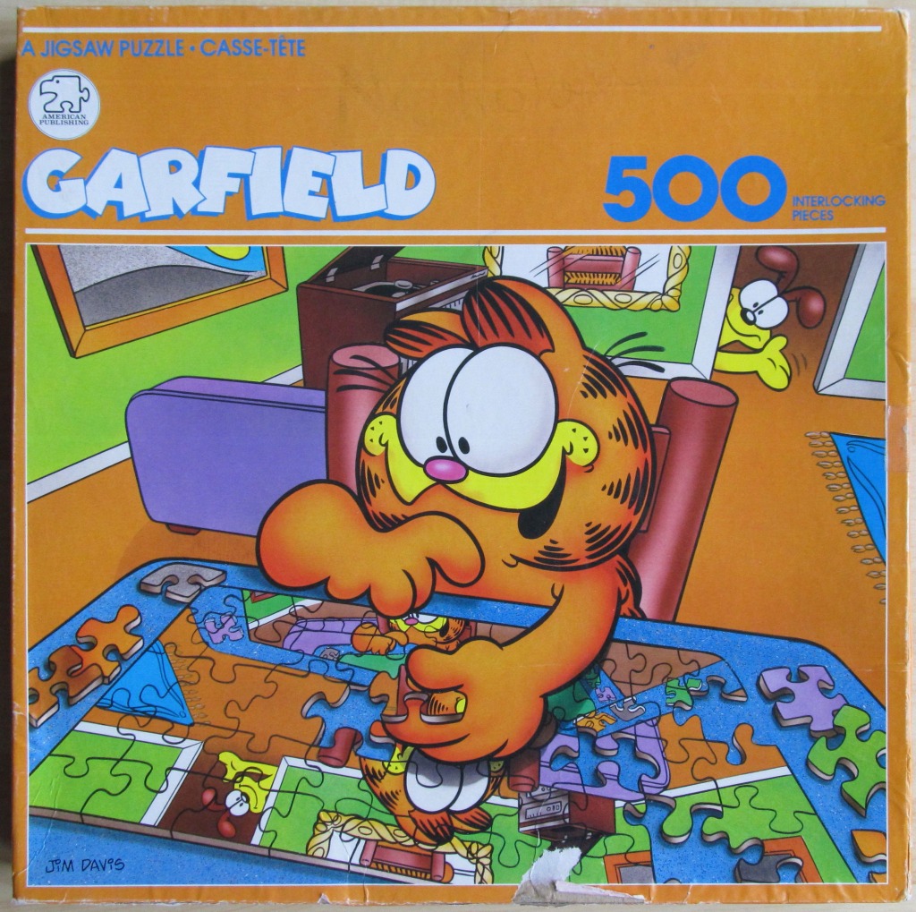 Garfield the cat working on a jigsaw puzzle featuring a picture of himself and Odie.